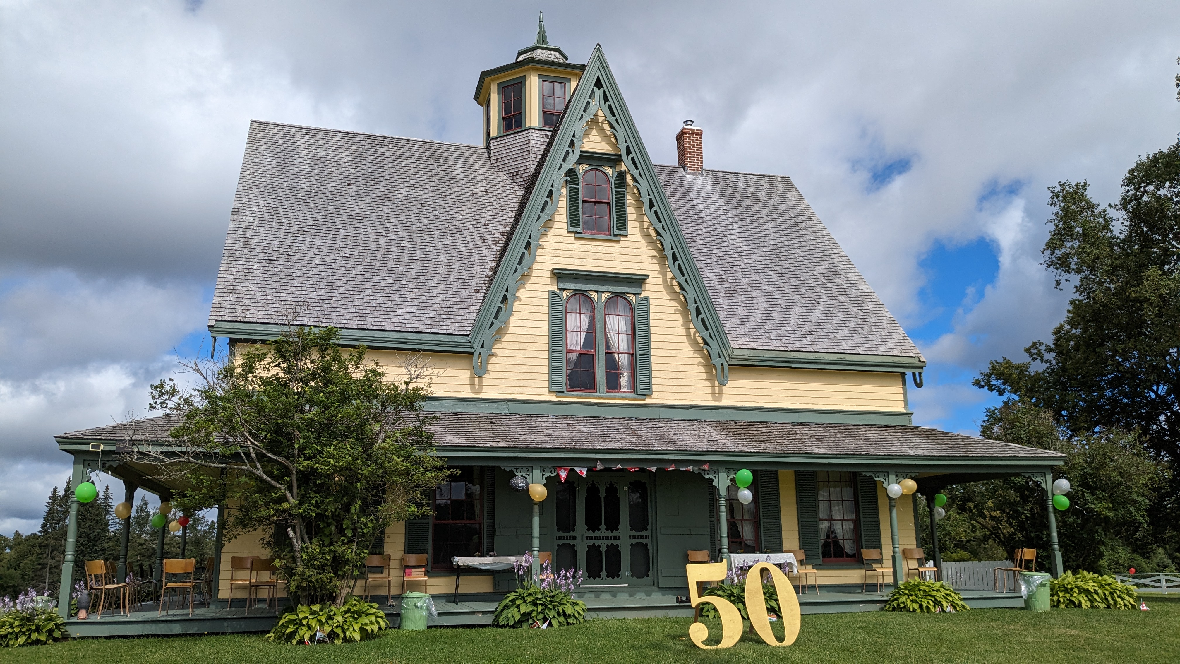 A large yellow house with a giant 50 in front.